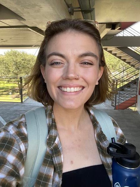 Woman wearing backpack and carrying water bottle