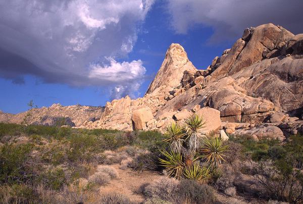 photo of granite mountains with blue skies and clouds