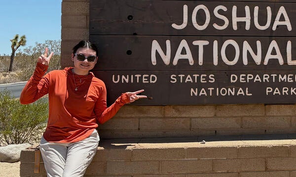 intern in front of Joshua Tree sign