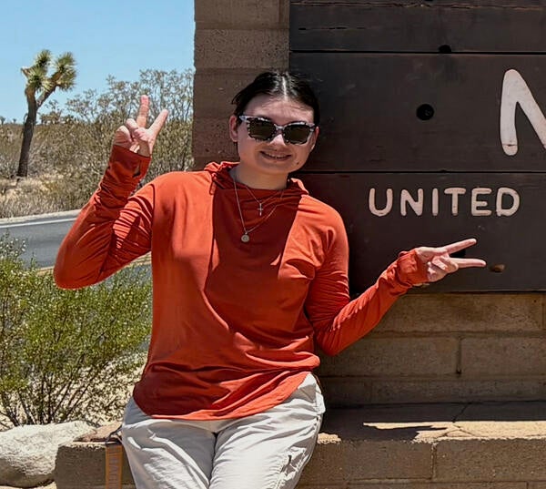 intern in front of Joshua Tree sign