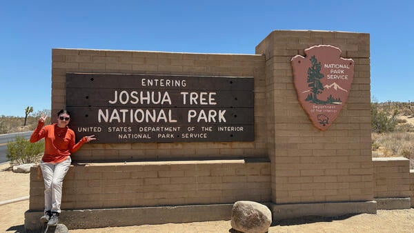 intern in front of Joshua Tree sign